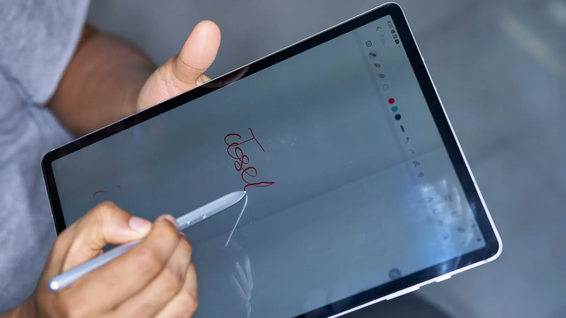 a person writing on a tablet with a pen